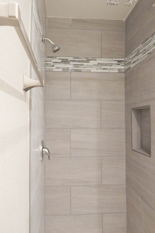 A shower area with a glass door and a shower head.