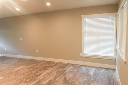 A room with a window and wooden flooring.