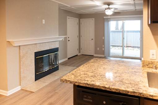 A kitchen with a granite countertop and a fireplace.