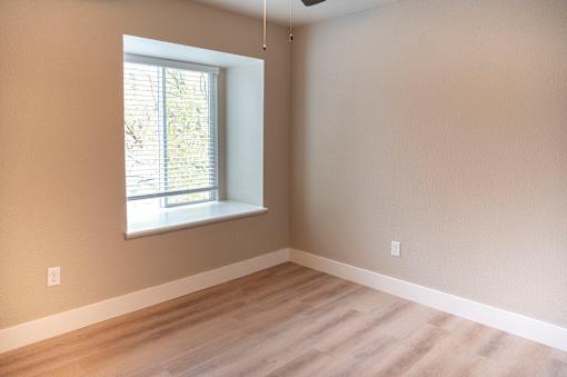 A room with a window and a ceiling fan.