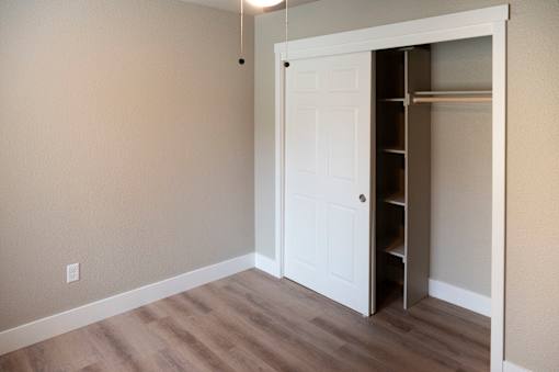 A white door is open to a pantry with shelves.