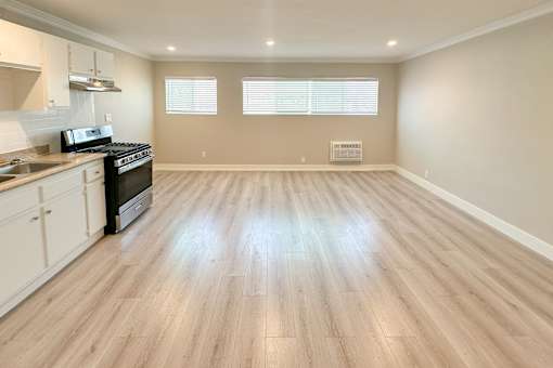 A kitchen with wooden floors and a stove top oven.