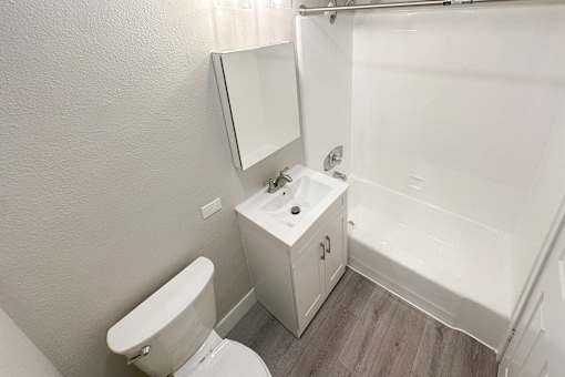 A white bathroom with a toilet, sink, and bathtub.