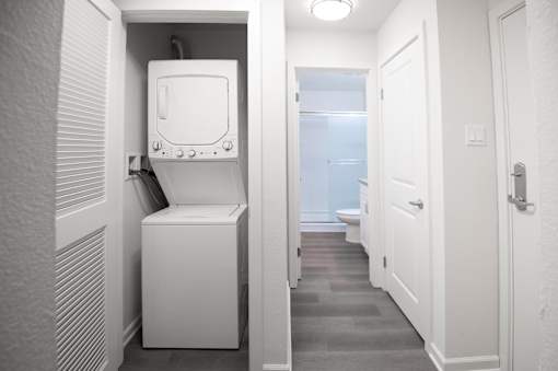 A white toilet is in a small room with a door on the right.