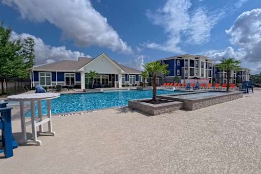 A pool area with a blue and white building in the background.