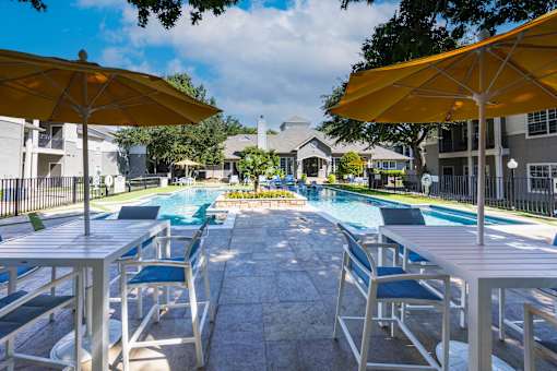 A pool surrounded by chairs and umbrellas.