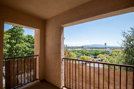 A balcony with a view of a town and a body of water.