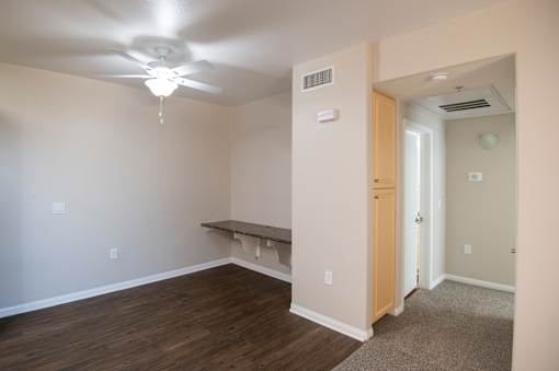 A room with a ceiling fan and a bench.
