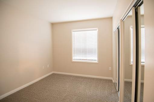 A room with a window and carpeted floor.