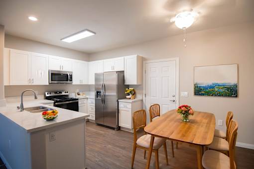 A kitchen with a table and chairs.