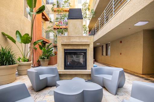 A modern outdoor seating area with a fireplace.