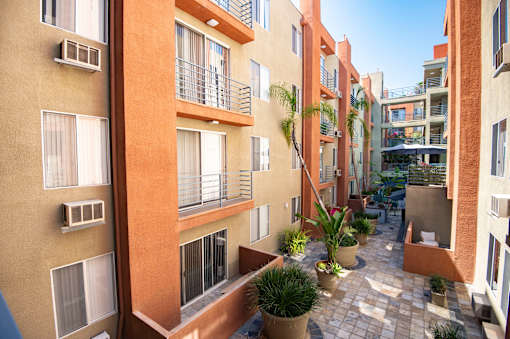 A courtyard surrounded by buildings with potted plants.