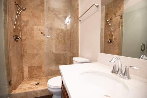 A bathroom with a toilet, sink, and shower.