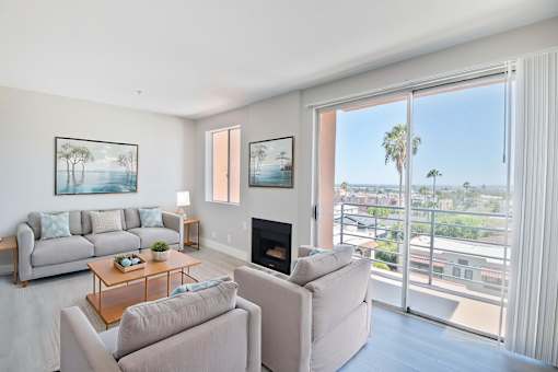 A living room with a fireplace and a view of the city.