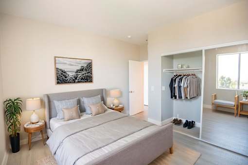 A bedroom with a large bed and a painting on the wall.