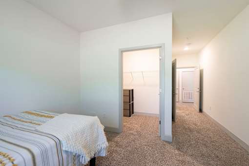 A bedroom with a bed, dresser, and closet.