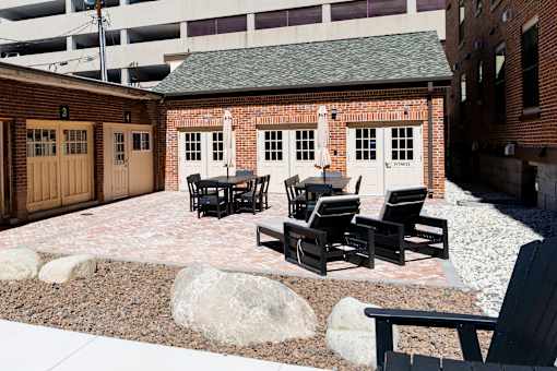 A patio with black chairs and a table.
