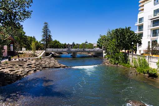 A river flows through a city with a bridge crossing over it.