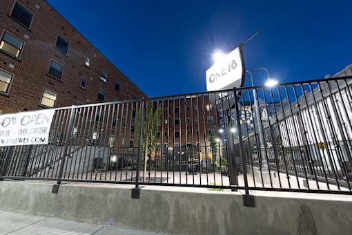 A building with a sign that says "ONE18" is shown at night.