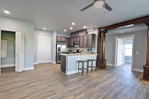 A kitchen with a bar and a ceiling fan.