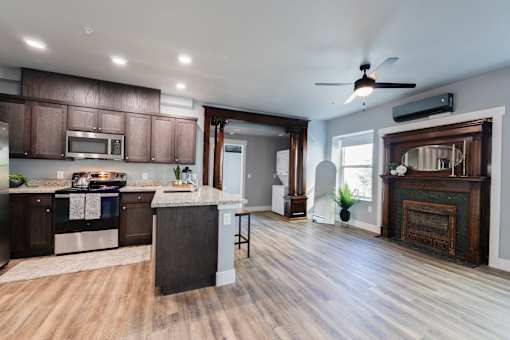 A modern kitchen with dark wood floors and a large island.