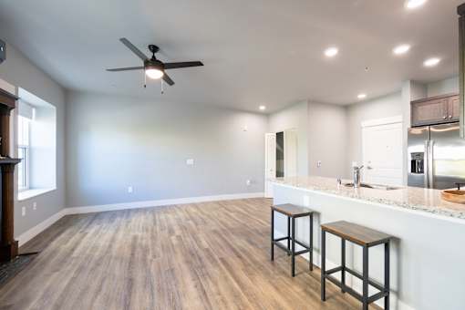 A kitchen with a bar area and a ceiling fan.