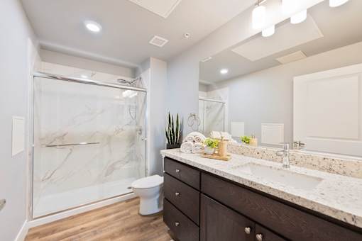 A bathroom with a marble shower and sink.