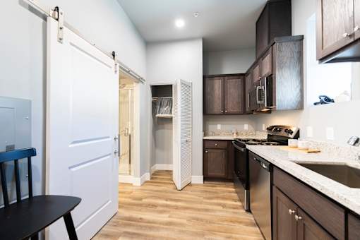 A kitchen with a table and chairs in front of a white door.