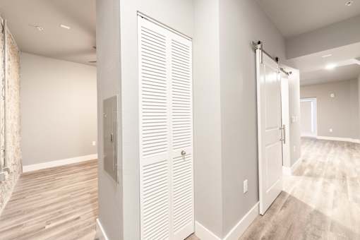 A white closet with a sliding door and a mirror on the wall.
