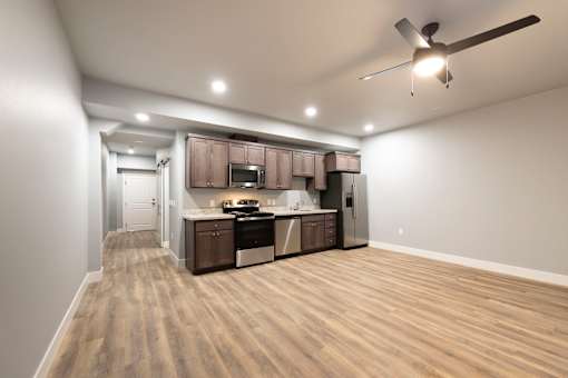 A spacious kitchen with wooden flooring and modern appliances.