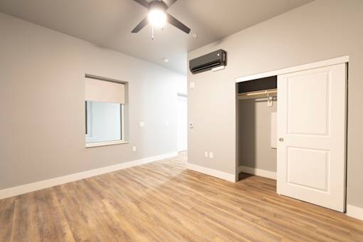 A room with a ceiling fan and a window.