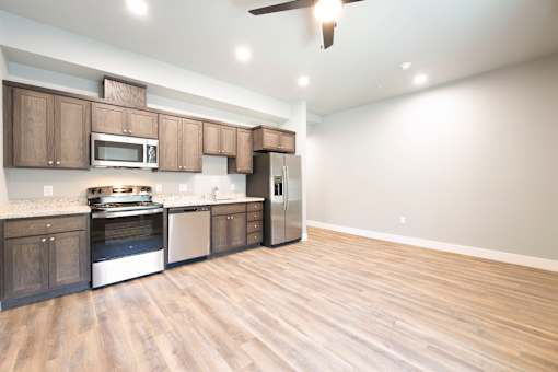 A kitchen with wooden cabinets and a stainless steel refrigerator.
