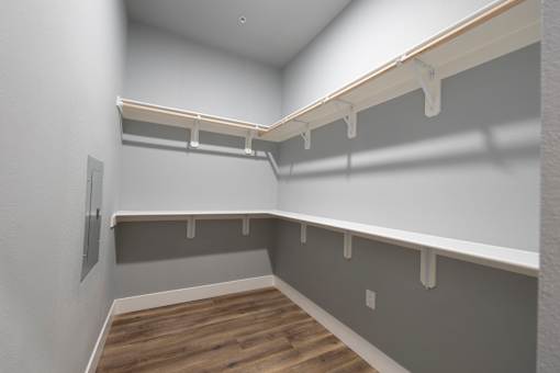 A long, empty hallway with a white wall and a grey wall.