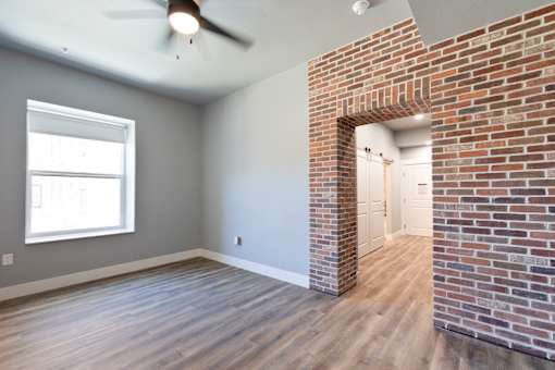 A room with a brick wall and a ceiling fan.