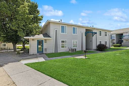 A residential building with a green lawn in front.