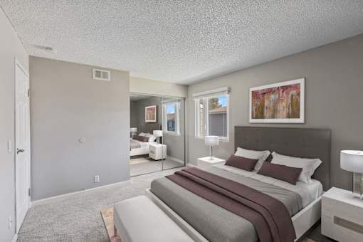 A bedroom with a large bed and a painting on the wall.