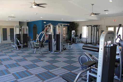 A gym with a variety of equipment including treadmills, weights, and exercise machines.