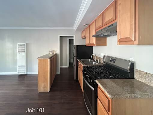A kitchen with wooden cabinets and black appliances.