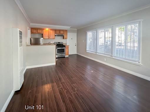 A kitchen with wooden floors and white walls.