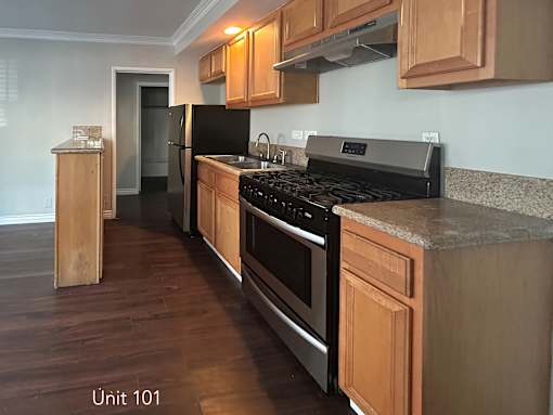 A kitchen with wooden cabinets and a black stove top oven.