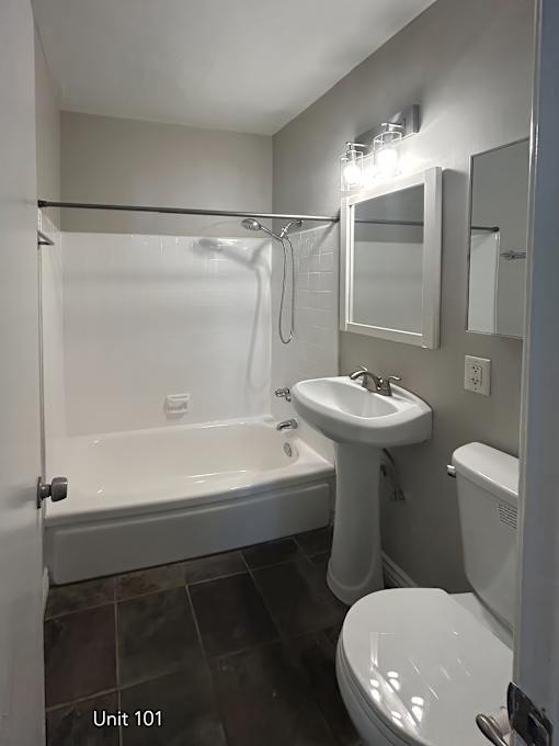A white bathroom with a toilet, sink, and bathtub.