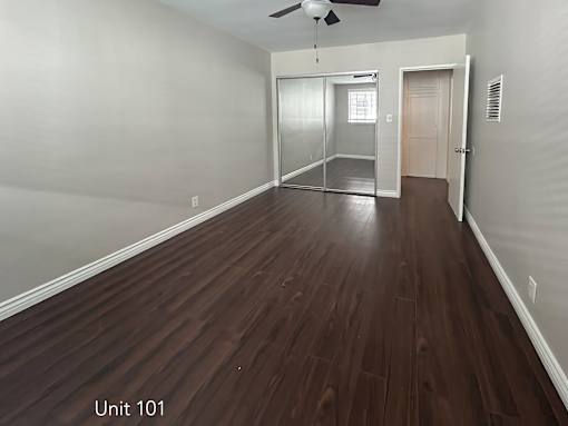 A room with wooden flooring and a ceiling fan.