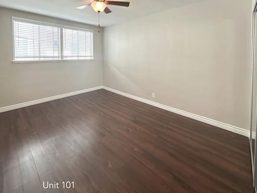 A room with wooden flooring and a ceiling fan.