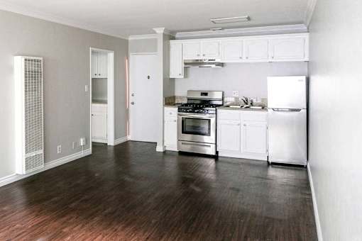 a kitchen with white cabinets and a stove and a refrigerator