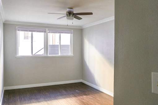 an empty room with a ceiling fan and a window