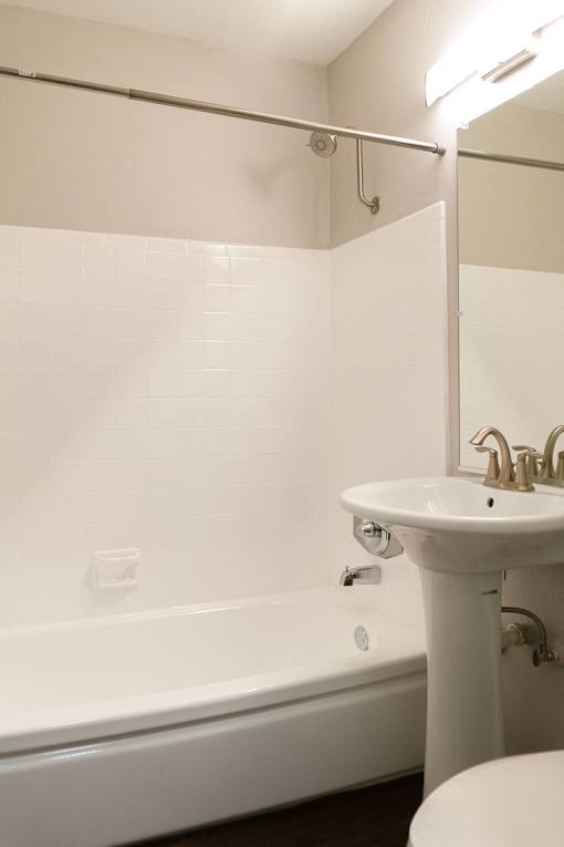 a white bathroom with a sink and a bath tub