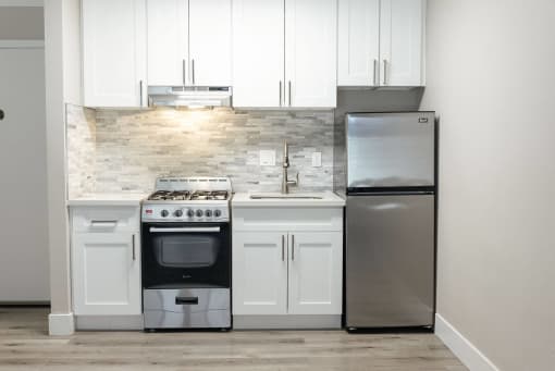 a white kitchen with stainless steel appliances and white cabinets