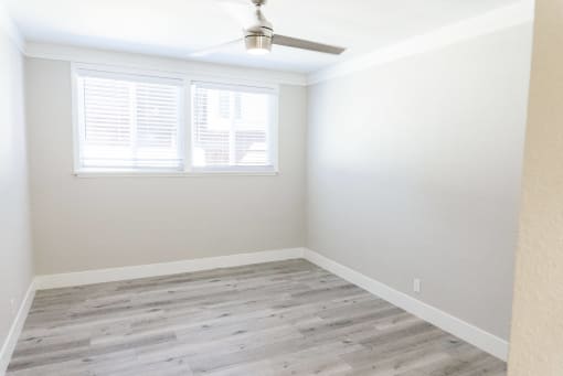 an empty room with wood floors and a window