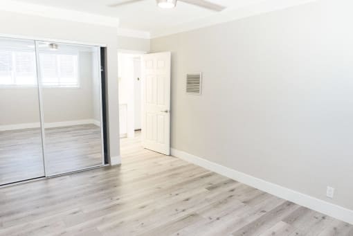 an empty room with white walls and a sliding glass door