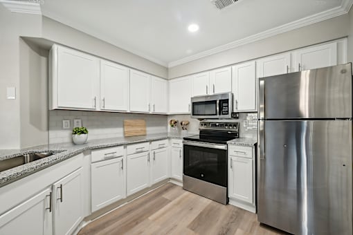 A modern kitchen with stainless steel appliances and white cabinets.